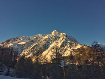 Scenic view of snowcapped mountains against clear blue sky