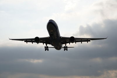 Low angle view of airplane flying against sky