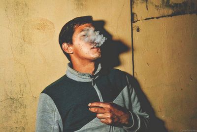 Close-up of young man standing on wall