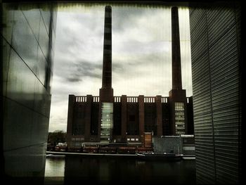 Buildings in city against cloudy sky