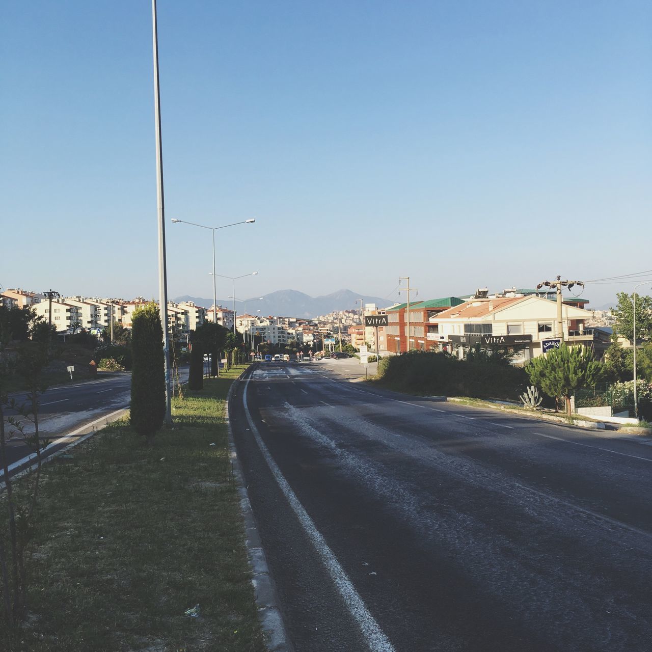 clear sky, road, the way forward, built structure, architecture, blue, diminishing perspective, vanishing point, long, empty, day, city, sky, outdoors, no people, country road, grass, nature, sunny