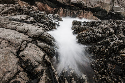 Water flowing on rocky beach