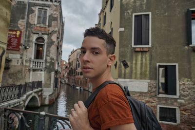Portrait of young man looking at city buildings