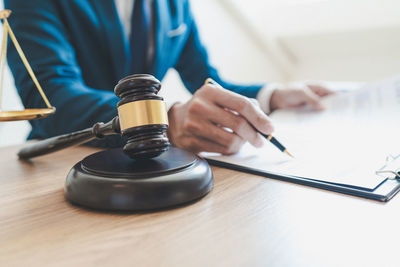 Midsection of lawyer working on table