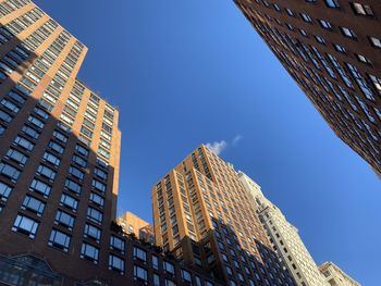 Low angle view of modern buildings against clear blue sky