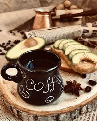 Close-up of coffee cup and avocado on table