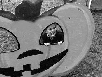 High angle view of boy shouting seen through artificial jack o lantern