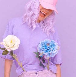 Smiling of woman with flowers against colored background