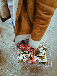 Low section of woman standing on street during winter