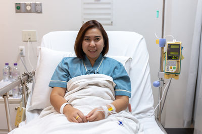 Portrait of a smiling young woman lying on bed