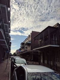 Vehicles on road against sky in city