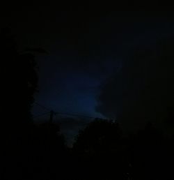 Low angle view of silhouette trees against sky at night