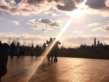 People at observation point against sky during sunset