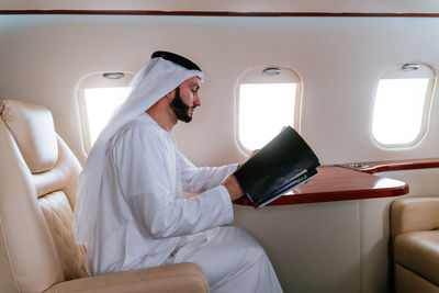 Smiling businessman traveling in corporate jet