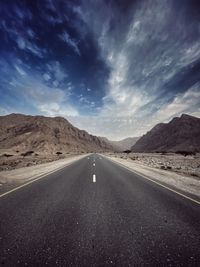 Road amidst desert against sky