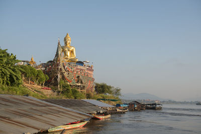 Temple by building against clear sky