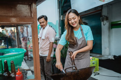 Portrait of smiling friends standing in kitchen