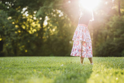 Low section of woman walking on grass