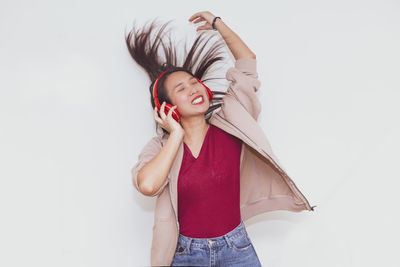 Young woman standing against white background