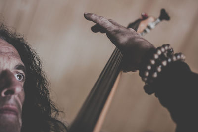 Mature man playing musical instrument at home