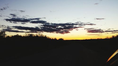 Scenic view of silhouette road against sky during sunset