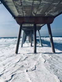 Pier over sea against sky during winter
