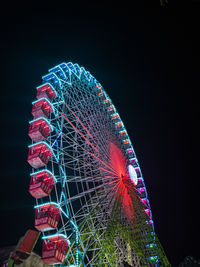 Low angle view of illuminated ferris wheel against sky at night