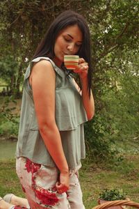 Young woman holding ice cream while standing on land