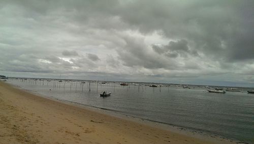 Scenic view of beach against cloudy sky