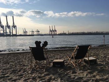 People sitting on beach against sky