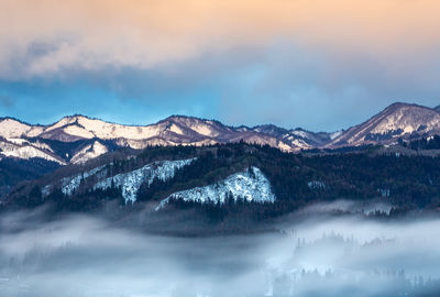 Scenic view of snowcapped mountains with mist