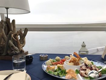 Food on table by window against sky