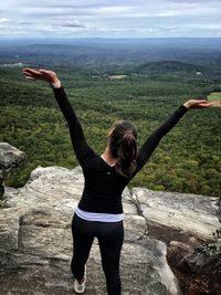 Full length of young woman hand on landscape against sky