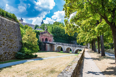 Arch bridge amidst trees against sky