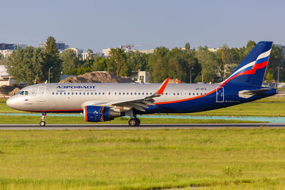 Airplane on airport runway against sky