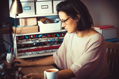 Woman sitting on table at home