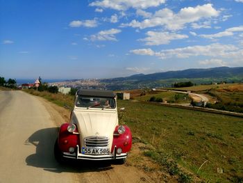 Car on road by land against sky