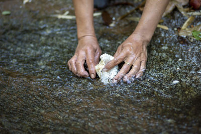 High angle view of hands on wet land