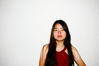 Portrait of smiling young woman against white background