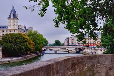 Bridge over river in city against sky