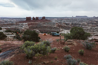 Campsite with a jeep and orange tent in the maze canyonlands utah
