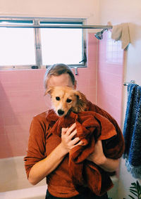 Portrait of woman with dog at home