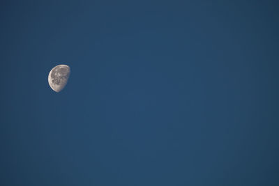 Low angle view of moon against clear blue sky