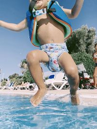 Full length of boy enjoying in swimming pool