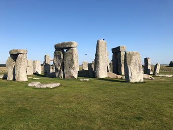 Stonehenge on field against clear sky