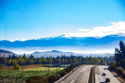 Road by mountains against blue sky