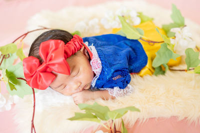 High angle view of cute baby girl lying on bed