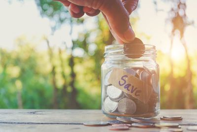 Close-up of hand holding jar against blurred background