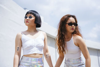 Lesbian couple holding hands while standing outdoors
