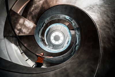 Low angle view of boy standing on spiral staircase